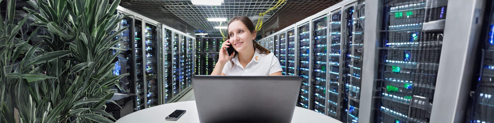 Freundliche Mitarbeiterin telefoniert im Rechenzentrum.