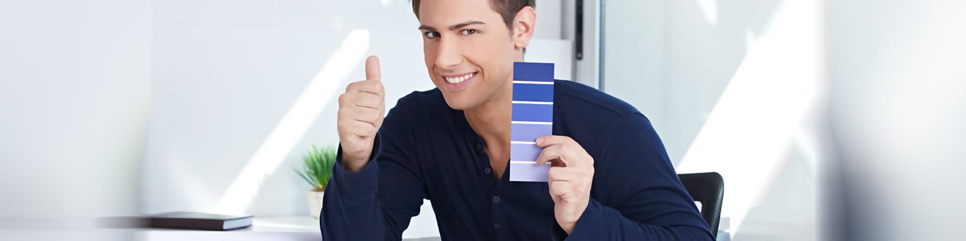 Ein Designer am Schreibtisch mit einer Farbpalette in der Hand in Schrobenhausen.